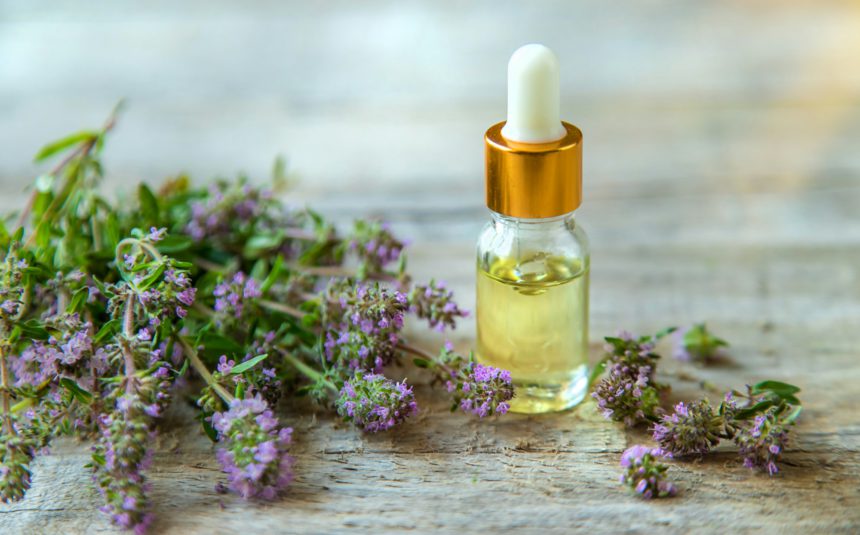 Essential oil of thyme in a bottle. Selective focus.